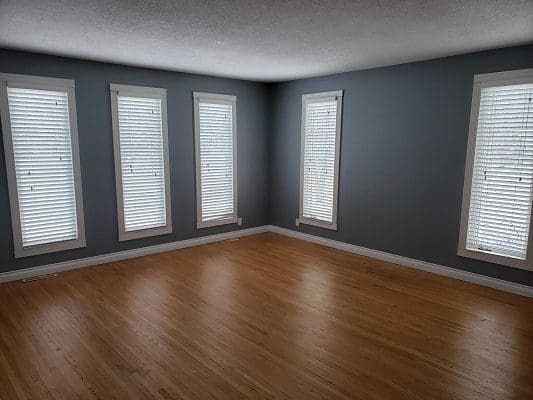 Empty room with blue walls and white shutters.