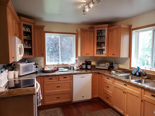 A kitchen with wooden cabinets and a microwave.