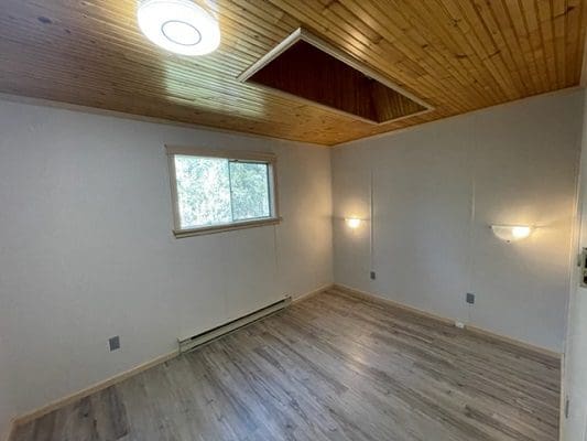 An empty room with wood floors and a ceiling fan.