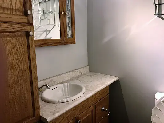 A small bathroom with a sink and mirror.