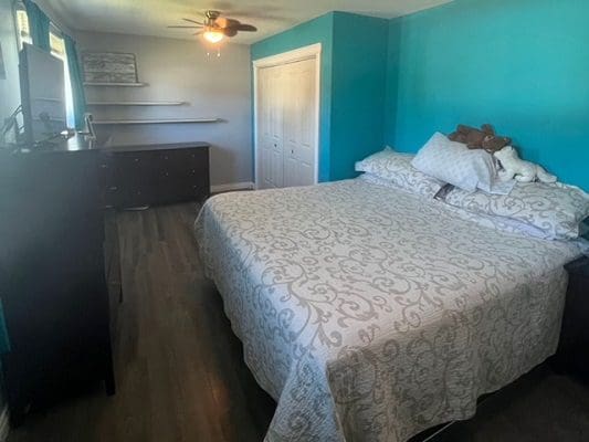 A bedroom with blue walls and a bed.