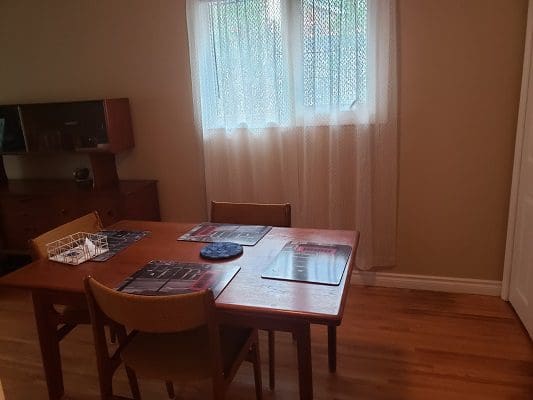 A room with a table and chairs and a window.