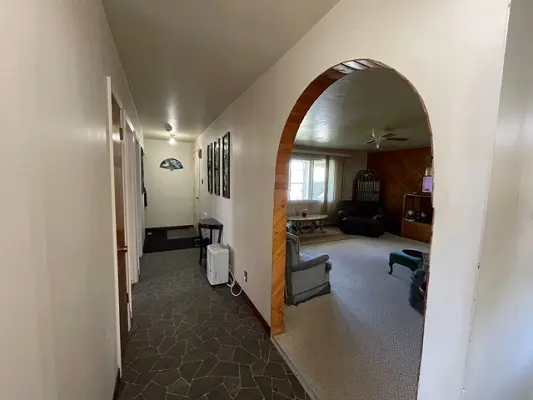 A hallway with an archway leading to a living room.