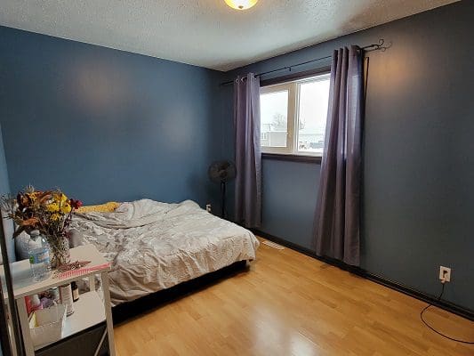 A bedroom with blue walls and a bed.