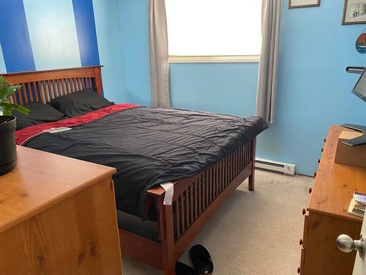 A bedroom with blue walls and a bed.