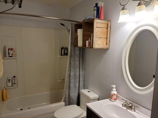 A bathroom with a toilet, shower, and sink.