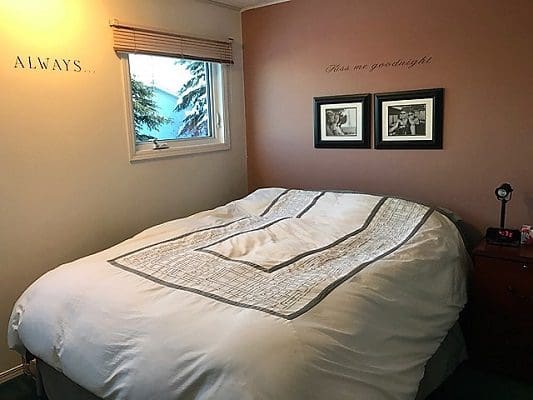 A bedroom with a bed and a window.
