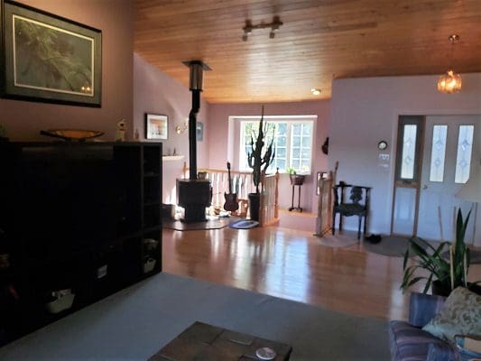 A living room with wood floors and a tv.
