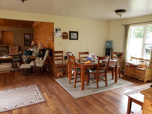 A living room with wood floors and a dining table.