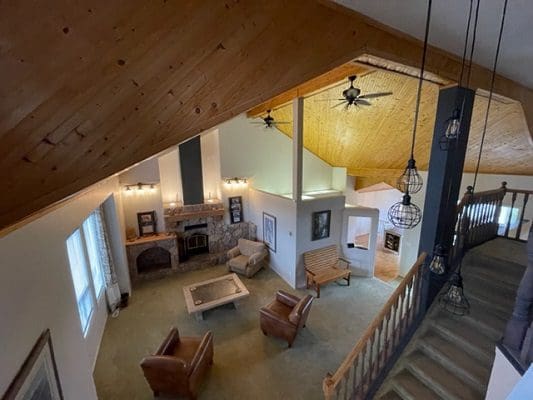 An aerial view of a home with wood floors and a fireplace.