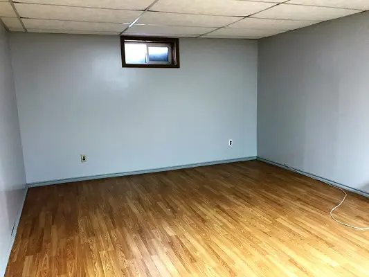 An empty room with wood floors and a window.