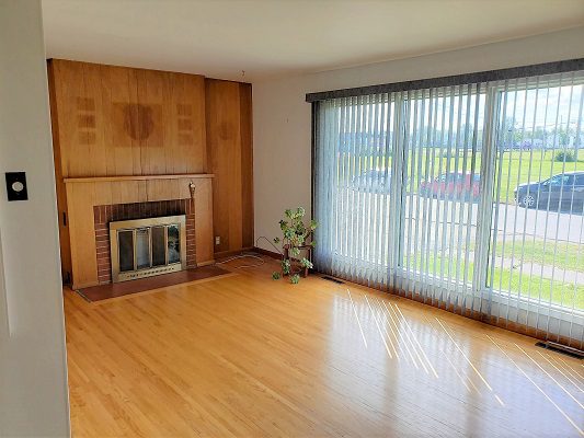 A living room with hardwood floors and a fireplace.