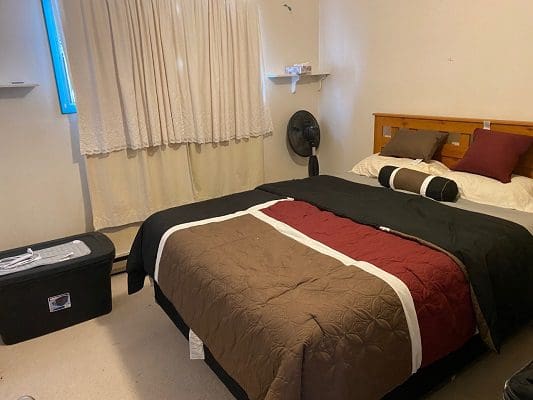 A bedroom with a bed and a bedside table.