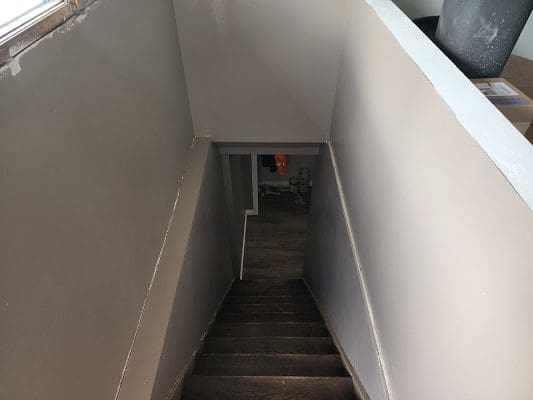 A stairway leading to a room with a wooden floor.