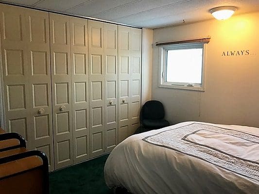 A bedroom with a bed and a closet.