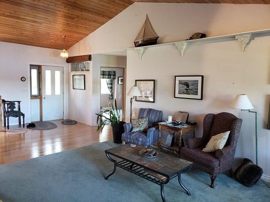 A living room with wood ceilings and a couch.