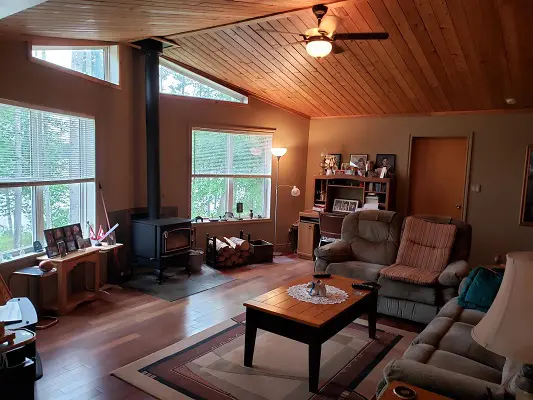 A living room with hardwood floors and a wood burning stove.