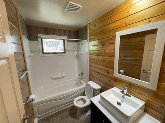 A bathroom with wood paneling and a toilet.
