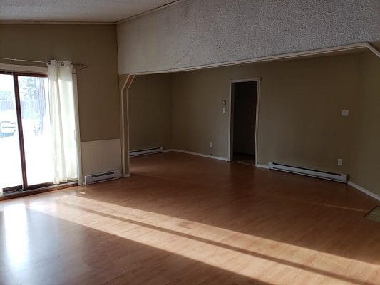 A living room with hardwood floors and a window.