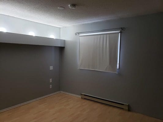A room with a wooden floor and a window.