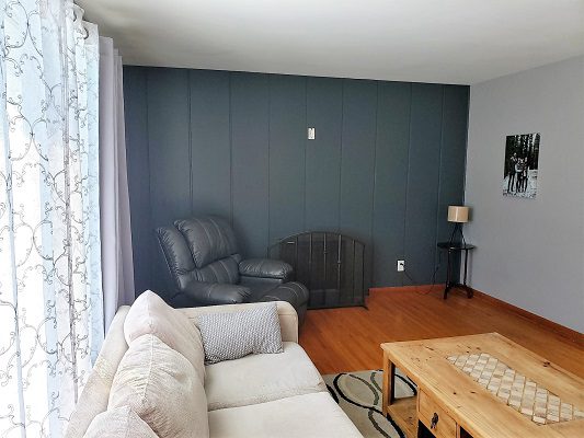 A living room with gray walls and wood floors.