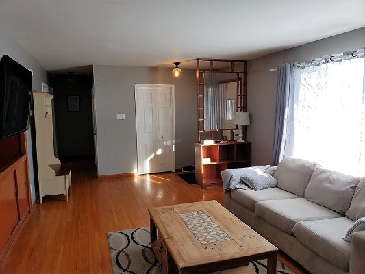 A living room with a couch, coffee table and tv.