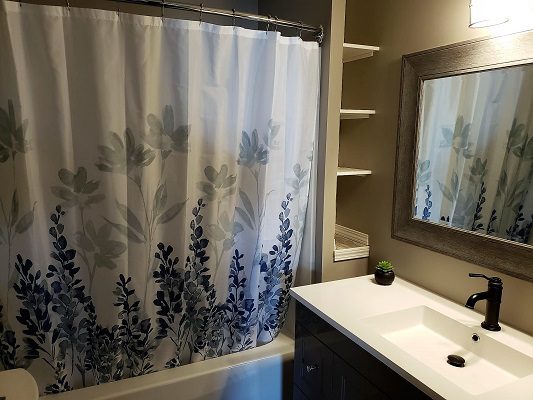 A bathroom with a blue and white shower curtain.