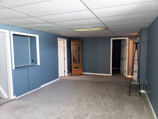 An empty room with blue walls and a closet.