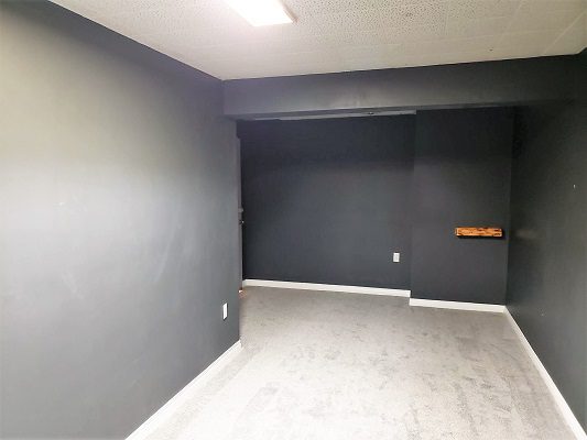 An empty room with gray walls and a wooden floor.