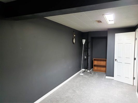 An empty room with gray walls and a door.