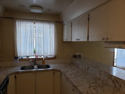 A kitchen with white cabinets and a sink.