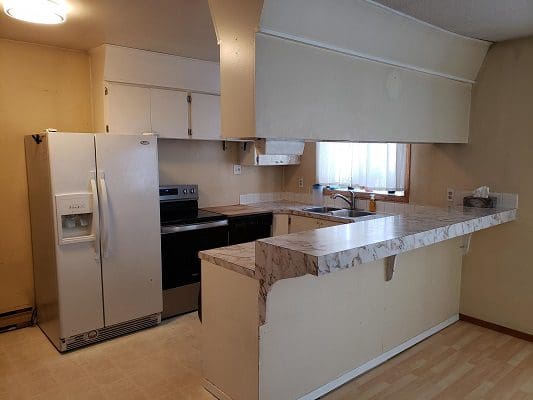 A kitchen with a stove and refrigerator.