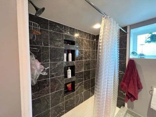 A bathroom with a shower and a towel rack.