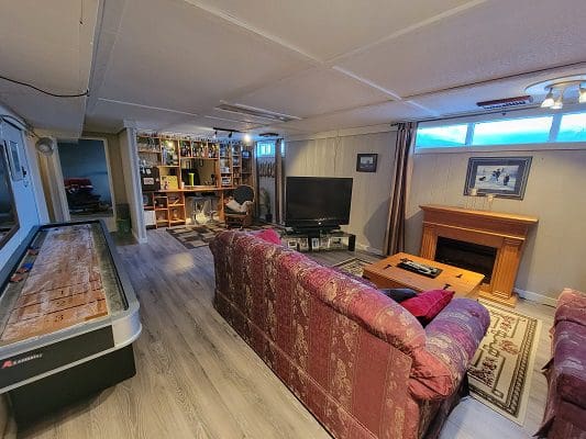 A living room with a pool table and a ping pong table.