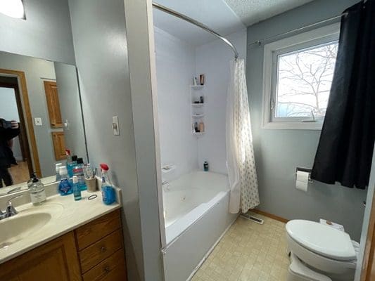 A bathroom with a toilet, sink and tub.