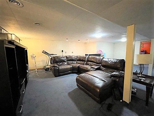 A living room with leather furniture and a television.