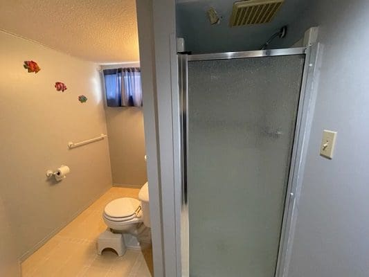 A small bathroom with a toilet and shower.