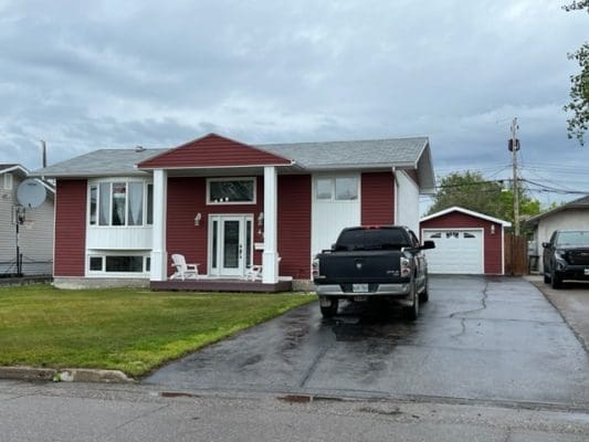 A house with a car parked in front of it.