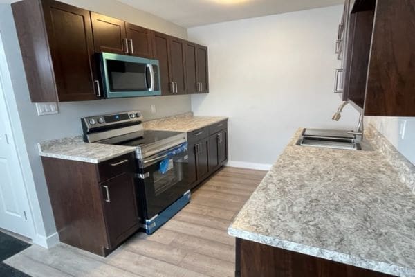 A kitchen with granite counter tops and stainless steel appliances.