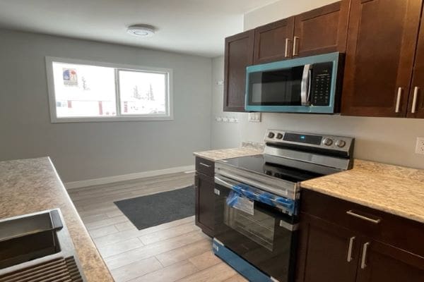 A kitchen with blue appliances and wood cabinets.
