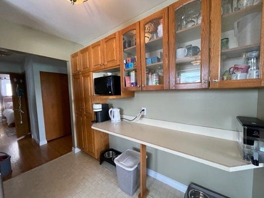 A kitchen with wooden cabinets and a microwave.