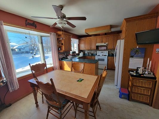 A kitchen with a table and chairs and a ceiling fan.