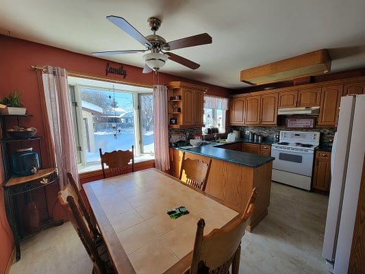 A kitchen with wooden cabinets and a ceiling fan.