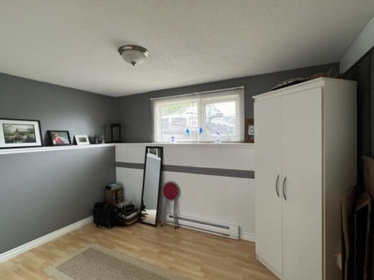 A room with gray walls and wood floors.