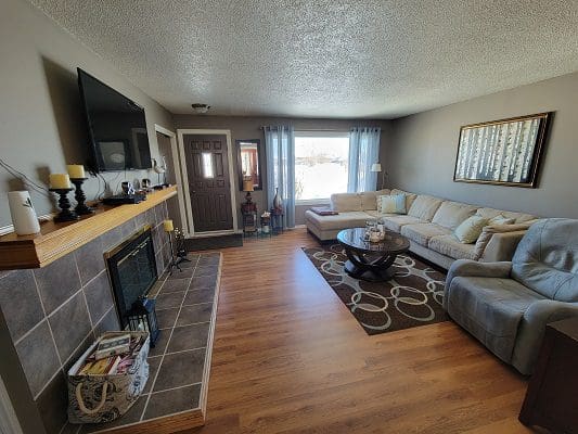 A living room with hardwood floors and a fireplace.