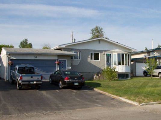 A house with two cars parked in front of it.