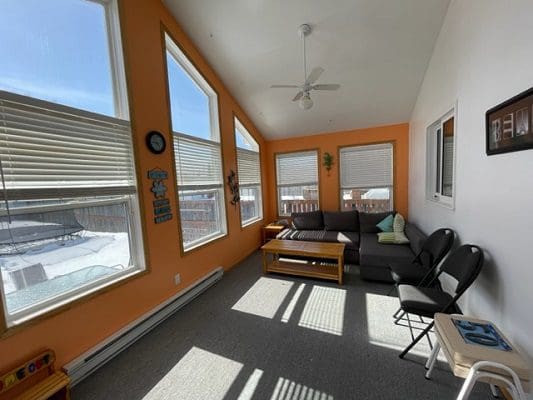 A living room with orange walls and a large window.