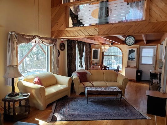 A living room with a fireplace and large windows.