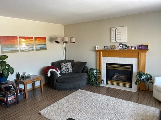 A living room with a fireplace and pictures on the wall.