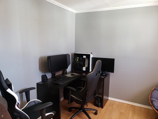 A computer desk with two monitors and a chair.